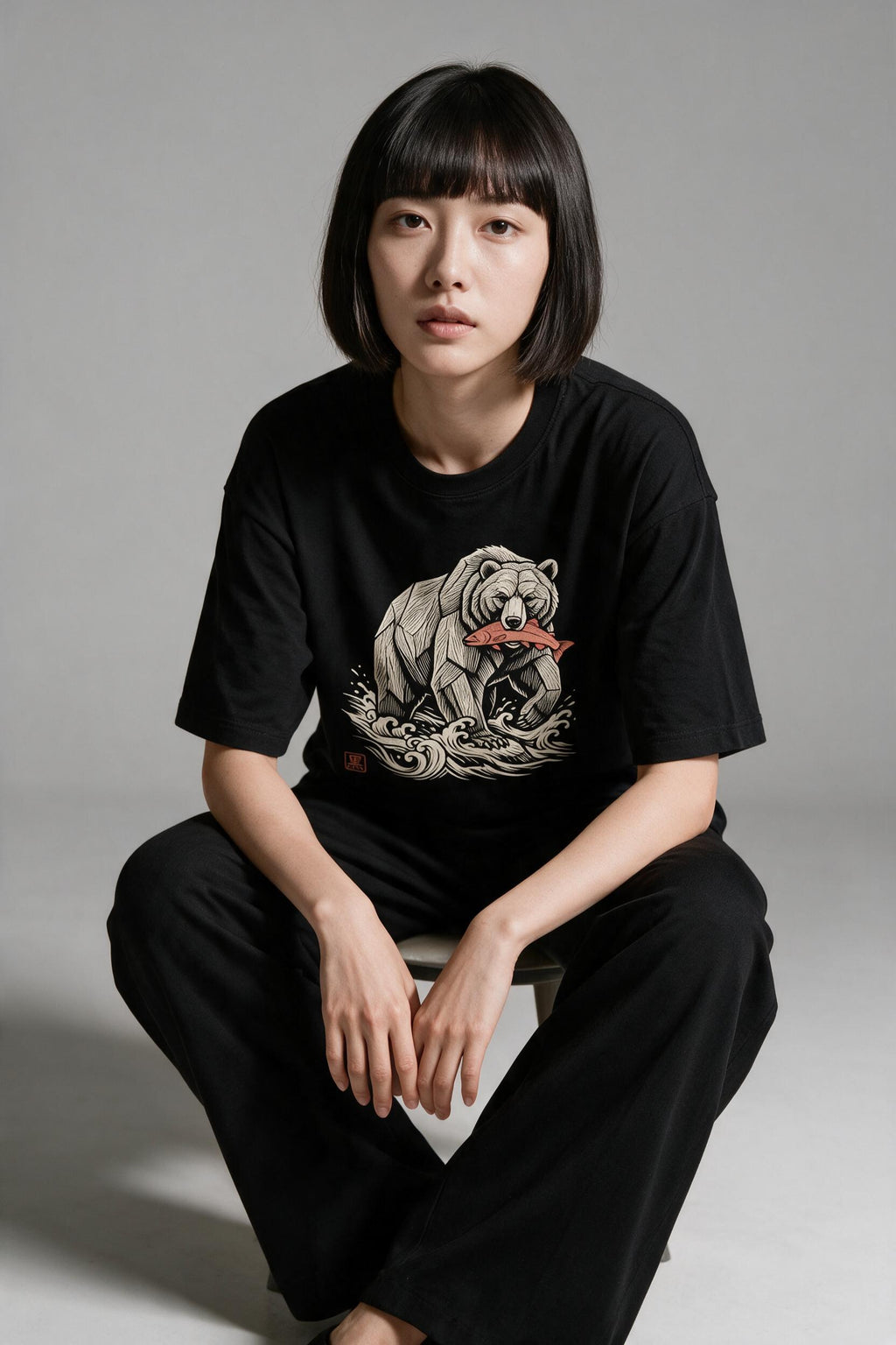 KUROI Kibori Kuma oversized tee worn by model, seated