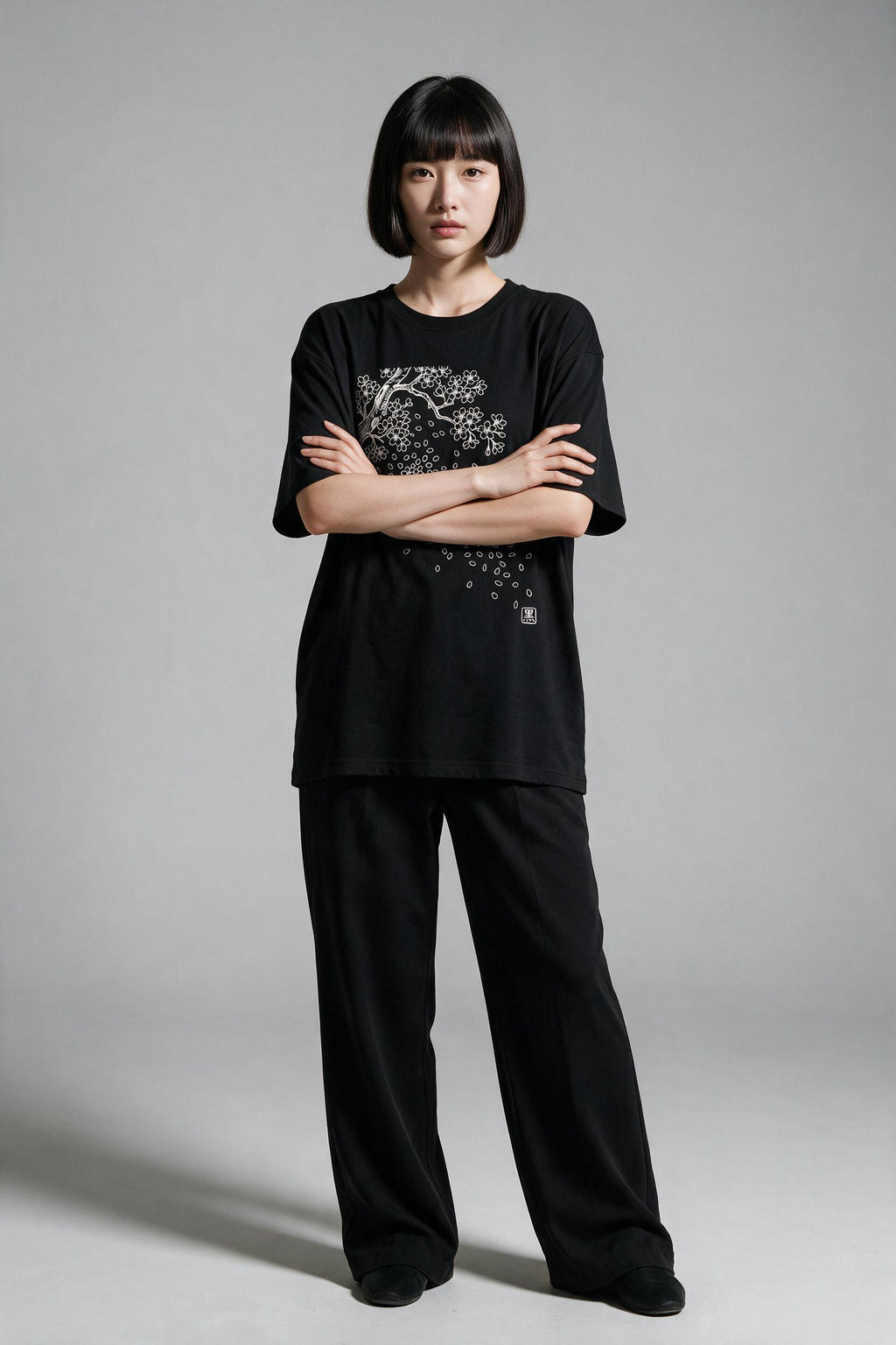 KUROI Sakura Fubuki oversized tee worn by model, arms crossed