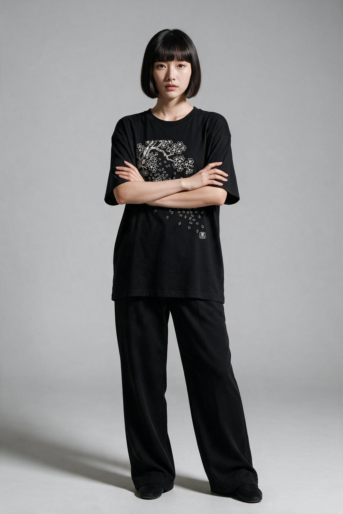 KUROI Sakura Fubuki oversized tee worn by model, arms crossed