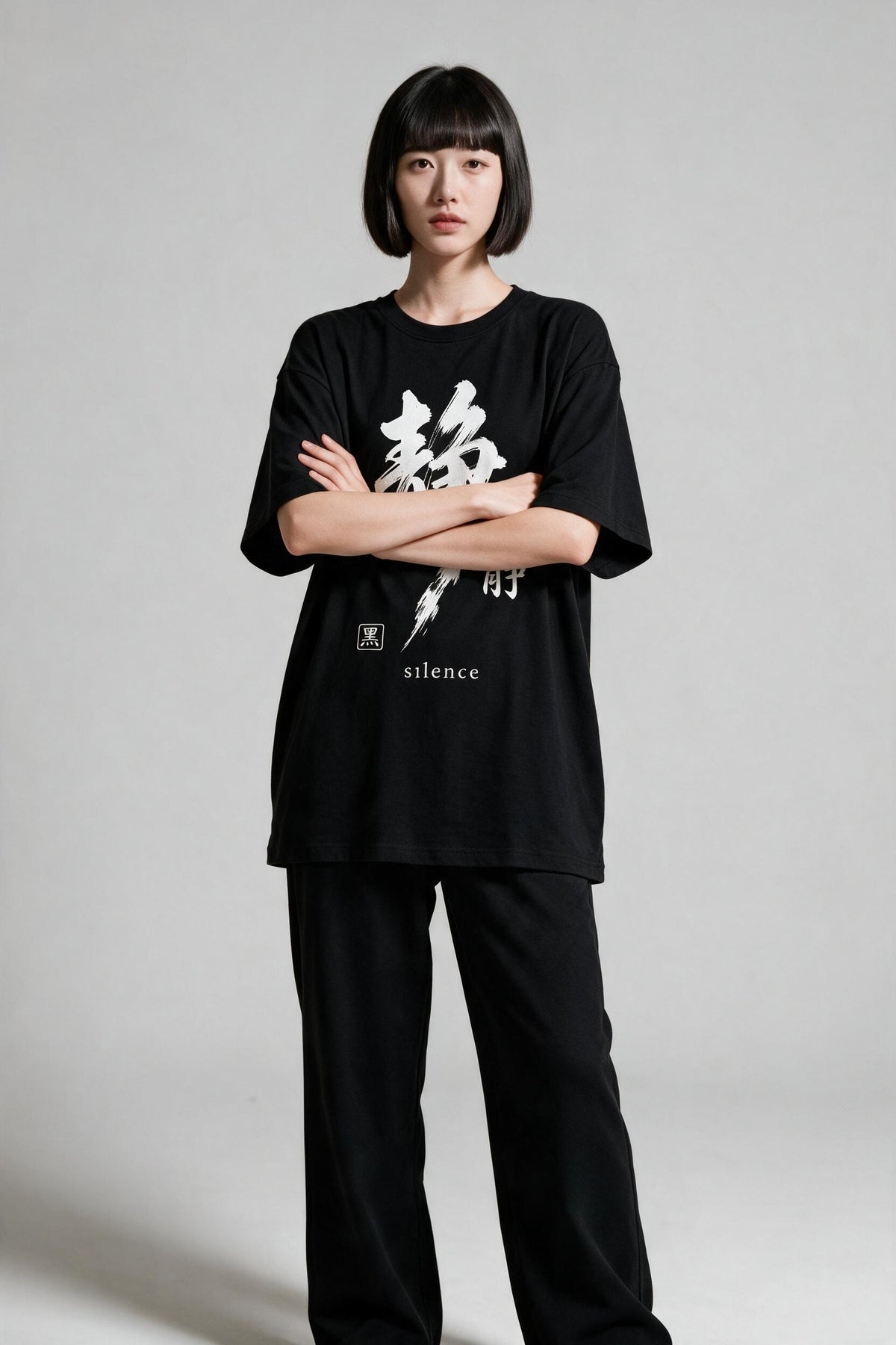 KUROI Seijaku oversized tee worn by model, arms crossed