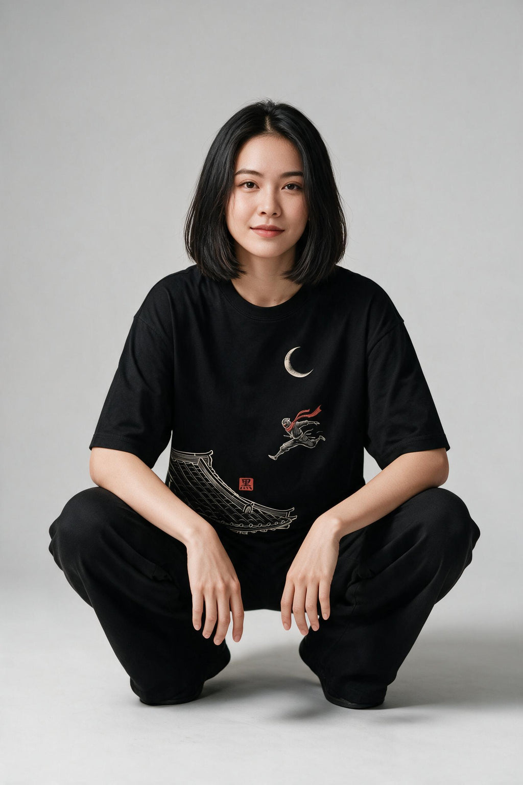 KUROI Shinobi oversized tee worn by model, squat